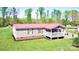Charming single-story home featuring red roof and cozy front porch in a serene, wooded setting at 161 Hickory Nut Dr, Statesville, NC 28677