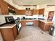 Well lit kitchen with brown cabinets, tile flooring and stainless steel appliances at 161 Hickory Nut Dr, Statesville, NC 28677