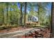 A-frame home with mature trees, wooden fence, and a gravel driveway at 1680 Ne 17Th Avenue Ct, Hickory, NC 28601
