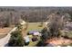 An aerial view shows this quiet home surrounded by a forest with a large lawn and a few outbuildings at 189 Woodwinds Dr, Mooresville, NC 28115