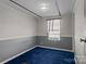 Simple bedroom featuring a blue carpet, light walls, and a window with curtains at 189 Woodwinds Dr, Mooresville, NC 28115