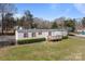 Cozy single-story home with red shutters, a front porch, and a spacious green lawn at 189 Woodwinds Dr, Mooresville, NC 28115
