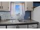 A kitchen sink features granite countertops, a tile backsplash, and white cabinets at 189 Woodwinds Dr, Mooresville, NC 28115