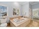 Bright bathroom featuring a large soaking tub beneath a window, a toilet, and a towel rack at 1921 Brandon Cir, Charlotte, NC 28211