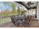 Inviting covered outdoor deck with fan, dining table, and comfortable wicker seating area at 1921 Brandon Cir, Charlotte, NC 28211