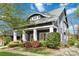 Charming home showcasing a meticulously landscaped front yard and inviting covered porch with classic columns at 1921 Brandon Cir, Charlotte, NC 28211