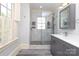 This bathroom features an updated shower, stone floor, and a gray vanity with a marble countertop at 2015 Dilworth E Rd, Charlotte, NC 28203