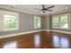 Spacious bedroom with hardwood floors, ceiling fan, and three windows, providing ample natural light at 2015 Dilworth E Rd, Charlotte, NC 28203