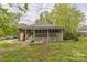 Home with overgrown yard and large screened-in porch awaiting renovations at 2106 A Ave, Charlotte, NC 28216