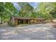 Unique home exterior boasts a covered parking area and multiple entry points, nestled among mature trees at 2415 Hargette Rd, Monroe, NC 28112