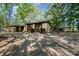 Wide angle shot of home exterior, with ample parking and garages surrounded by mature shade trees at 2415 Hargette Rd, Monroe, NC 28112