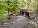 An elevated view of the outside of a garage style wooden building surrounded by trees at 2415 Hargette Rd, Monroe, NC 28112