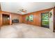 Inviting living room with a brick fireplace, ceiling fan, and wood paneling, perfect for relaxing and entertaining guests at 2415 Hargette Rd, Monroe, NC 28112
