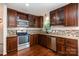 Kitchen with granite countertops, stainless steel appliances, and dark wood cabinets at 2528 Arnold Dr, Charlotte, NC 28205