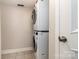 Laundry room features a stacked washer and dryer and tile flooring for added convenience at 2528 Arnold Dr, Charlotte, NC 28205