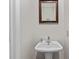 Clean pedestal sink with a framed mirror in a half bathroom at 2638 Dilworth Heights Ln, Charlotte, NC 28209