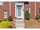 Close-up of the townhome's entrance with a glass-paneled front door and manicured shrubs at 2638 Dilworth Heights Ln, Charlotte, NC 28209