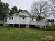 Exterior backyard view of a house with a deck, tidy lawn, and fresh mulch at 301 E 11Th St, Kannapolis, NC 28083