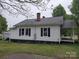 Charming exterior with white siding, black shutters, brick chimney, and a covered porch at 301 E 11Th St, Kannapolis, NC 28083