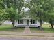 Charming single story home with white siding and a covered front porch, framed by mature trees at 301 E 11Th St, Kannapolis, NC 28083