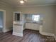 Spacious open living room with laminate flooring connecting to the kitchen featuring white cabinets at 301 E 11Th St, Kannapolis, NC 28083