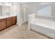Bright bathroom featuring a separate shower and soaking tub, offering a spa-like experience in your own home at 305 Augustus Ln, Mount Holly, NC 28120