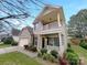 Charming two-story home featuring a two-car garage, inviting front porch and upper level balcony at 305 Augustus Ln, Mount Holly, NC 28120