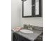 Bathroom with dark vanity, gray granite countertop, decorative towel, and mirror cabinet at 308 Greenwood Pl, Belmont, NC 28012