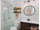 Modern bathroom featuring a glass-enclosed shower, floating shelves, and stylish vanity with round mirror at 308 Greenwood Pl, Belmont, NC 28012