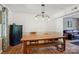 Dining room with hardwood floors, wooden table with bench seating, and modern light fixture at 308 Greenwood Pl, Belmont, NC 28012