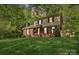 Charming two-story brick home with a well-manicured lawn and mature trees, creating an inviting curb appeal at 308 Greenwood Pl, Belmont, NC 28012
