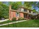 Side view of a two-story brick home with manicured lawn, black shutters, and a walkway to the front door at 308 Greenwood Pl, Belmont, NC 28012