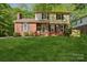 Charming two-story home with brick and siding exterior and a lush green lawn and black shutters at 308 Greenwood Pl, Belmont, NC 28012