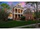 Stately two-story brick home featuring a welcoming front porch with elegant columns and manicured landscaping at 3301 Mcpherson St, Waxhaw, NC 28173