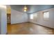 Living room with white walls, two windows, and wood flooring at 3379 Appletree Ct, Vale, NC 28168