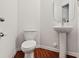 This bathroom features a sleek pedestal sink, modern fixtures, and hardwood floors at 3623 Danvers St, Charlotte, NC 28213