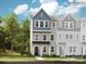 Charming three-story townhome with blue and beige accents, a black metal roof, and a well-manicured lawn at 4140 Skyboat Cir, Fort Mill, SC 29715