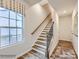Elegant staircase with wood treads, white risers, and a black metal railing against a window view at 4140 Skyboat Cir, Fort Mill, SC 29715