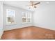 Bright bedroom with hardwood floors, two windows, and a ceiling fan at 5005 Sovereignty Ct, Charlotte, NC 28205