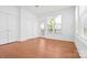 A sunny bedroom features hardwood floors, a window, and a door leading to a balcony at 5005 Sovereignty Ct, Charlotte, NC 28205