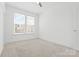 Well-lit bedroom with a large window, neutral carpet, and white walls, creating a serene space at 5005 Sovereignty Ct, Charlotte, NC 28205