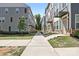 Wide shot of townhome exterior, showcasing uniform design, landscaping, and sidewalk at 5005 Sovereignty Ct, Charlotte, NC 28205