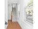 Bright hallway with hardwood floors and stairway, illuminated by natural light from a window at 5005 Sovereignty Ct, Charlotte, NC 28205