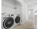 Bright laundry room with a modern washer and dryer set and wire shelving for storage at 5005 Sovereignty Ct, Charlotte, NC 28205