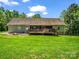 A well-maintained backyard with a deck, screened in porch, firepit and lush green lawn at 575 Hill Rd, Lincolnton, NC 28092