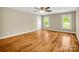 Bright bedroom featuring hardwood floors, access to the deck, and two windows at 575 Hill Rd, Lincolnton, NC 28092