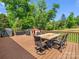 Wide angle of a spacious wooden deck with outdoor dining area, grill, playhouse and backyard at 575 Hill Rd, Lincolnton, NC 28092