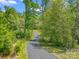 A long driveway meanders through a dense, green forest, leading to a secluded property at 575 Hill Rd, Lincolnton, NC 28092