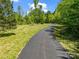 Scenic shot of a private paved driveway leading up to a property through lush green grass at 575 Hill Rd, Lincolnton, NC 28092