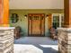 Inviting front porch with decorative columns, stone accents, and rocking chairs for relaxing at 575 Hill Rd, Lincolnton, NC 28092